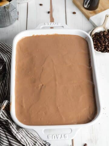 nutella tiramisu in a white baking dish before chilling in the fridge.