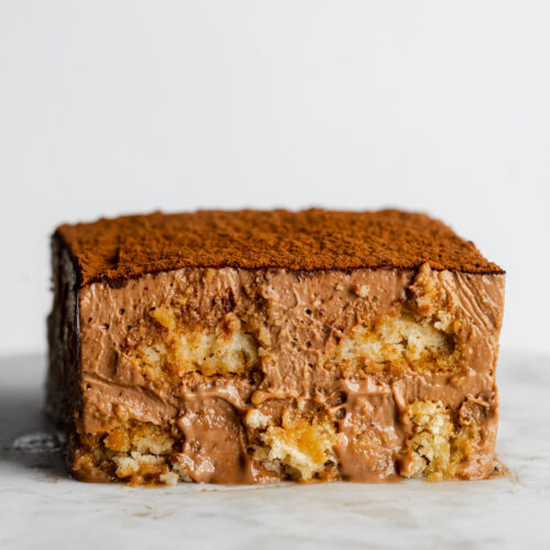 a slice of nutella tiramisu showing a cross-section against a marble background.