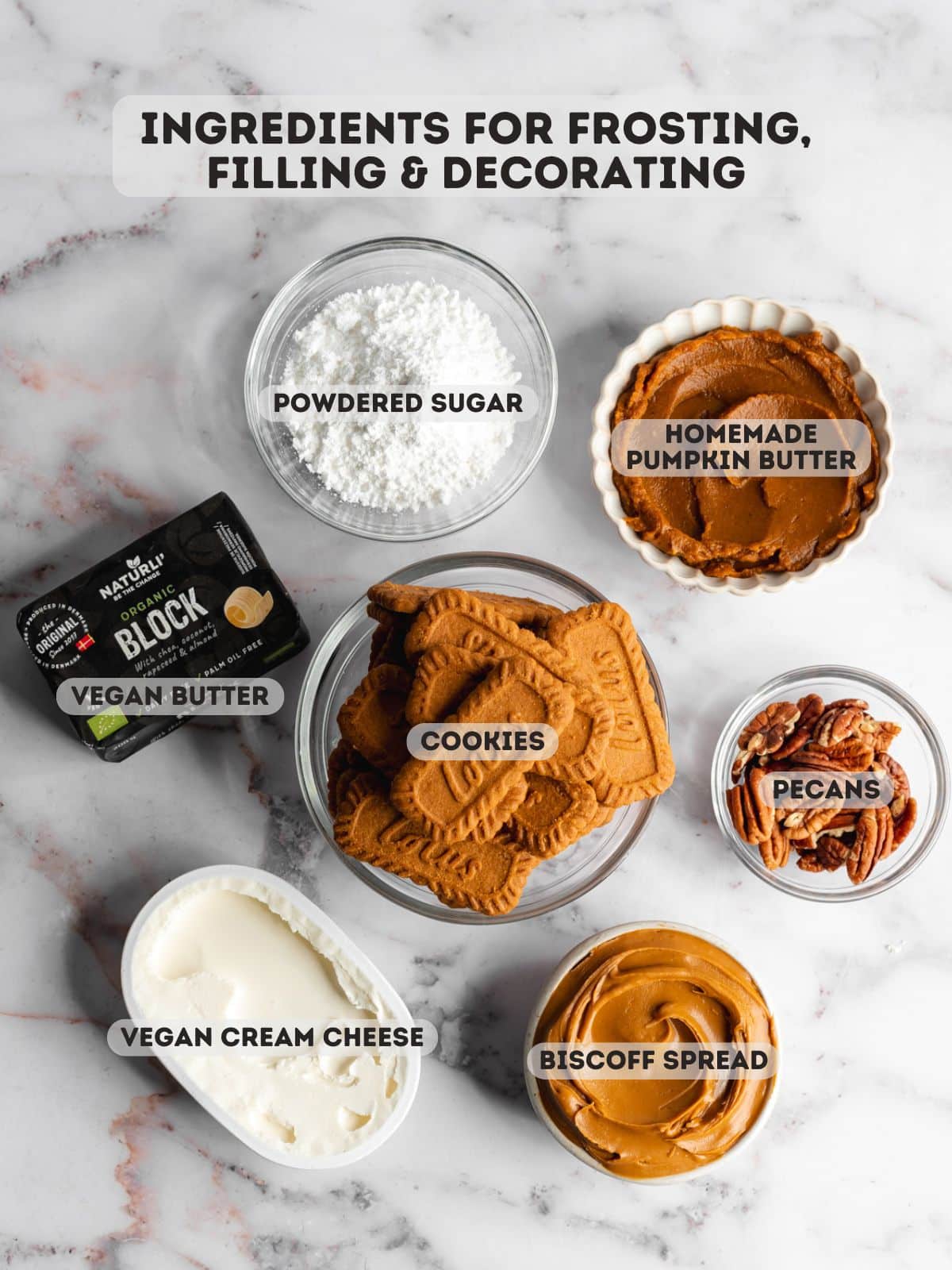 ingredients for pumpkin cream cheese frosting and biscoff truffles measured out in bowls on a marble surface.