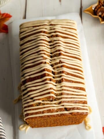 a loaf of maple pecan bread that's drizzled with brown butter icing.