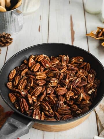 toasted pecan halves in a black skillet.