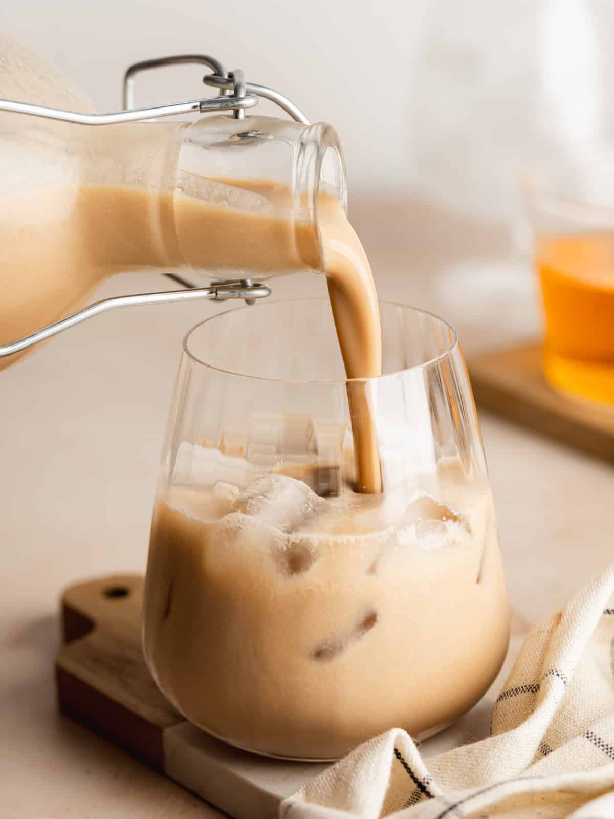 homemade baileys pouring into a glass with ice.