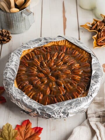 pecan pie with a foil pie shield around the outer crust to prevent burning.