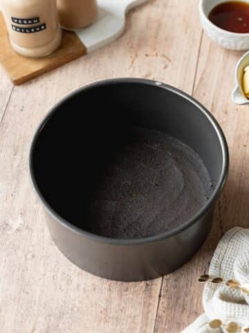 oreo cookie crust smoothed into the base of a cheesecake pan.