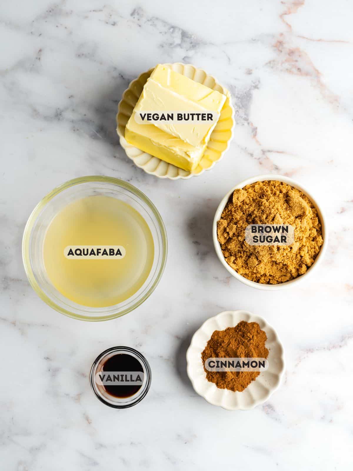 ingredients for vegan brown sugar buttercream measured in bowls on a gray marble surface.