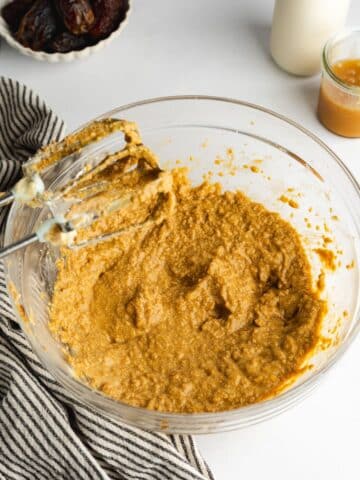 wet ingredients for sticky toffee pudding whisked in a glass bowl.