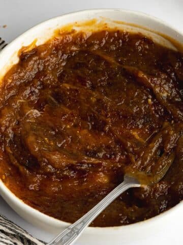 dates and hot water mashed into a paste in a bowl with a fork.