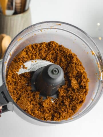 gingerbread cookie crumbs after blending in a food processor jug, resembling wet sand.