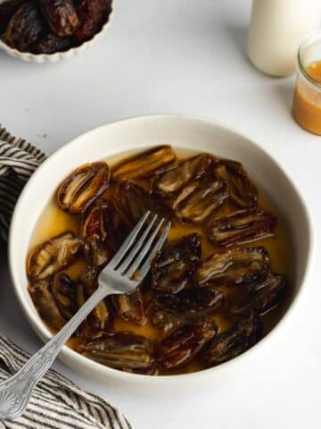 medjool dates chopped into pieces on place in a shallow bowl with water to soak.