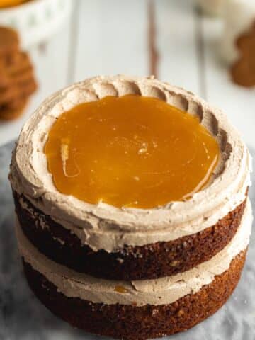 a layered gingerbread cake with a dam filled of caramel sauce on top.