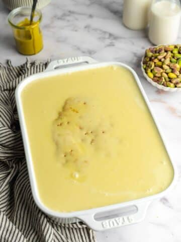 pistachio cake covered in three milk mixture before chilling overnight.