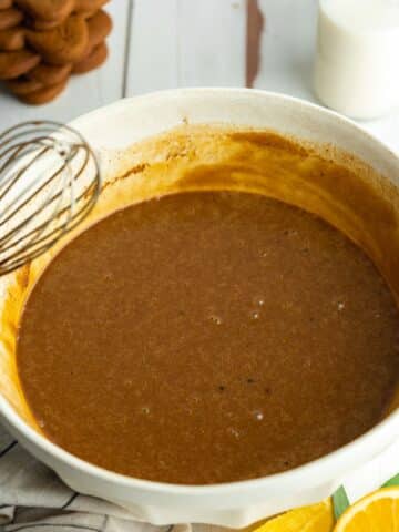 wet ingredients for orange gingerbread cake mixed together in a large ceramic bowl.