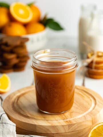 a jar filled with homemade orange caramel sauce.