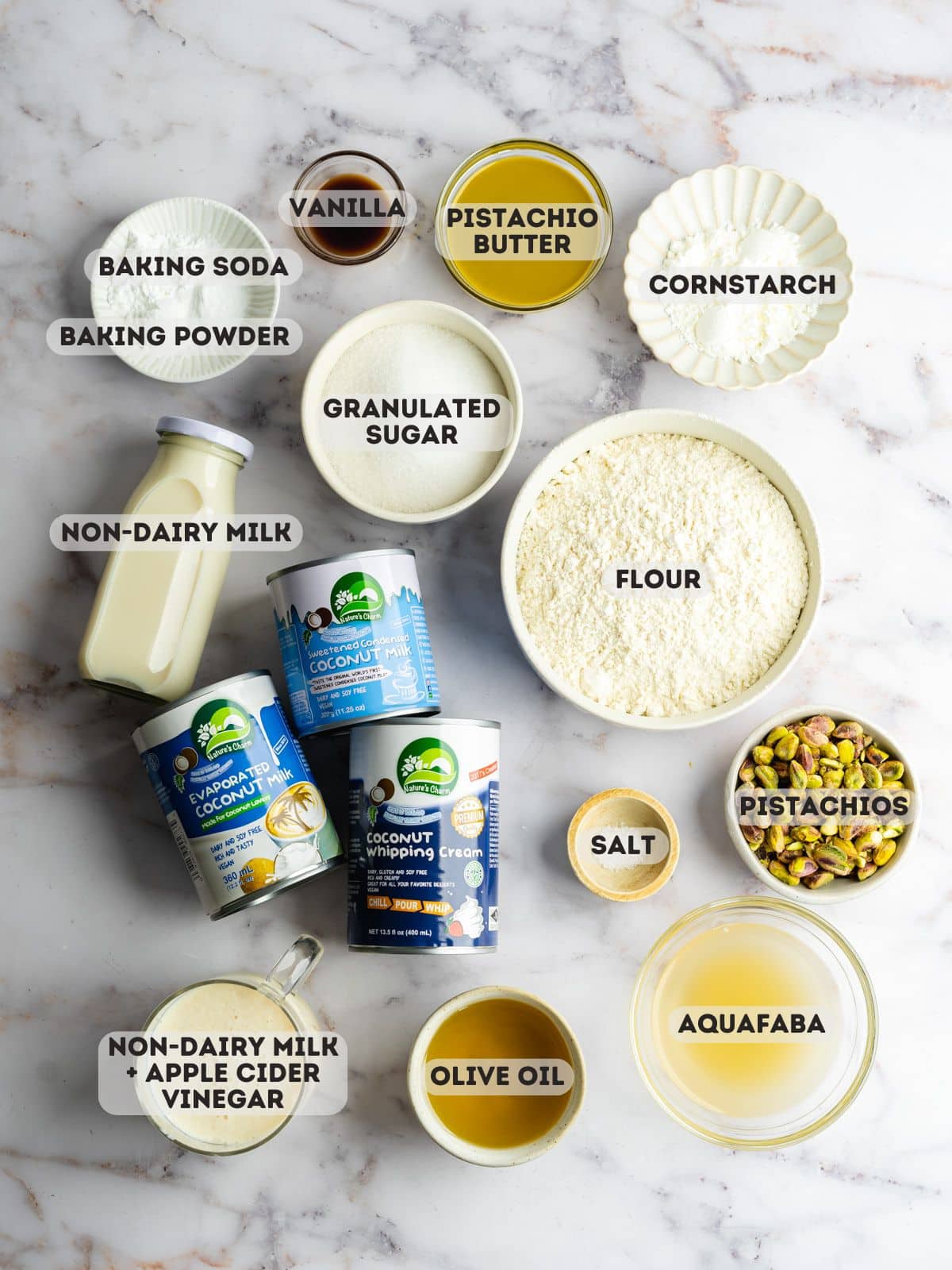 ingredients for pistachio milk cake measured out in bowls on a marble surface.
