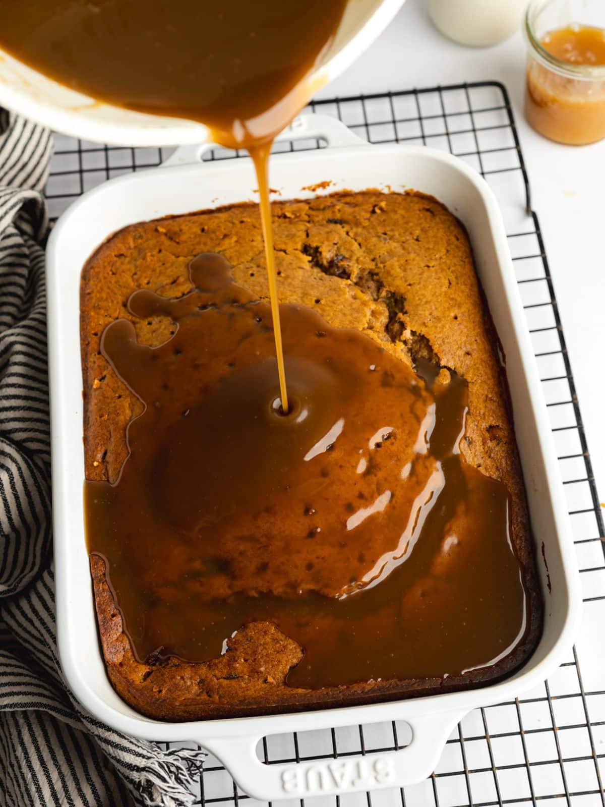 pouring warm toffee sauce over sticky date pudding.