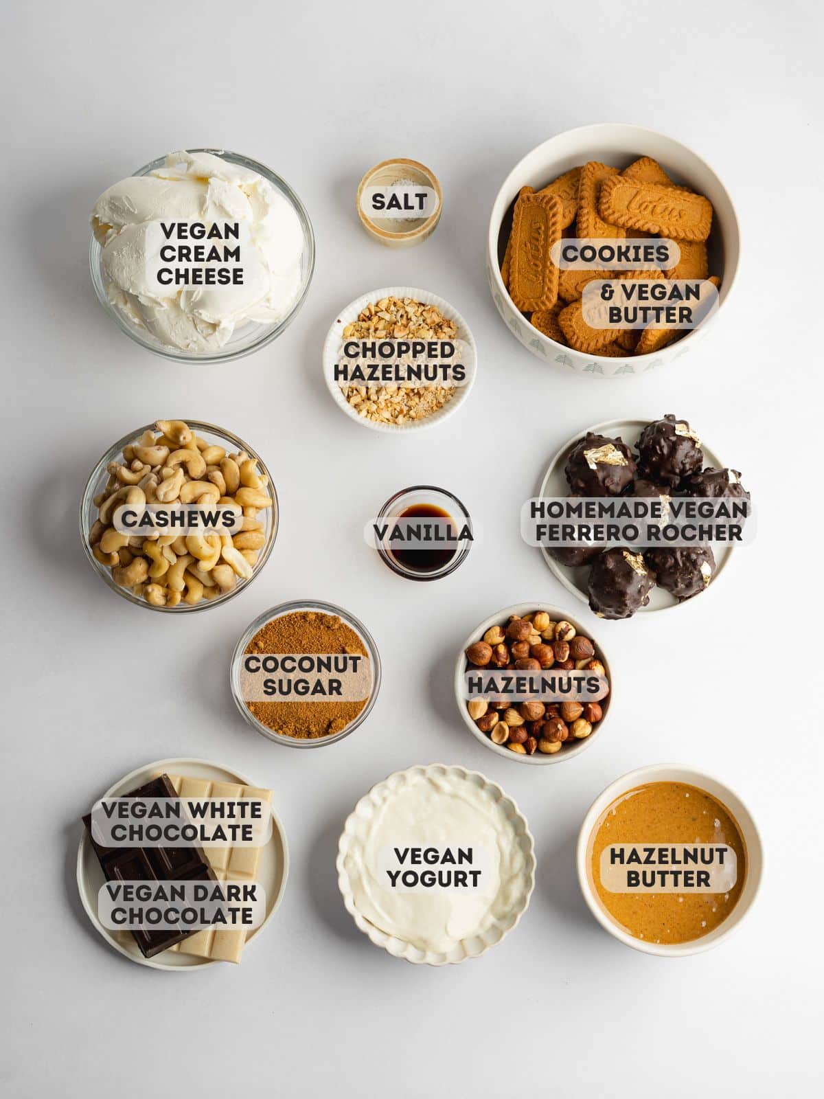 ingredients to make a dairy-free ferrero rocher-style cheesecake measured out in bowls on a light gray surface.
