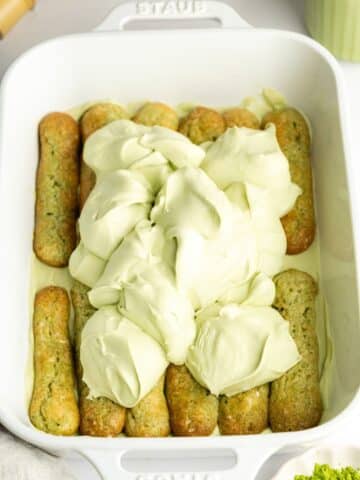 creamy matcha filling scooped on top of matcha-dipped ladyfingers in a staub baking dish.