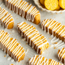 limoncello biscotti drizzled with lemon icing on a baking sheet.