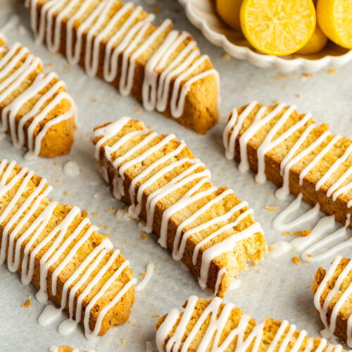 limoncello biscotti drizzled with lemon icing on a baking sheet.