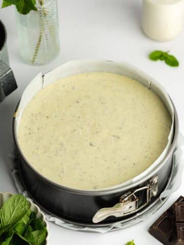 mint chocolate chip cheesecake in a lined cake pan before going into the fridge to set.