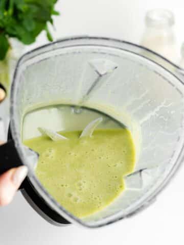 mint leaves and white chocolate ganache blended in a blender jug.