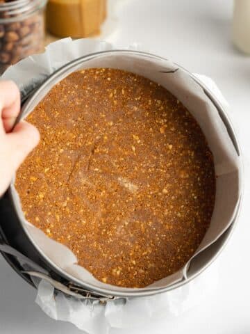 cheesecake crust pressed into the base of a parchment-lined springform pan.