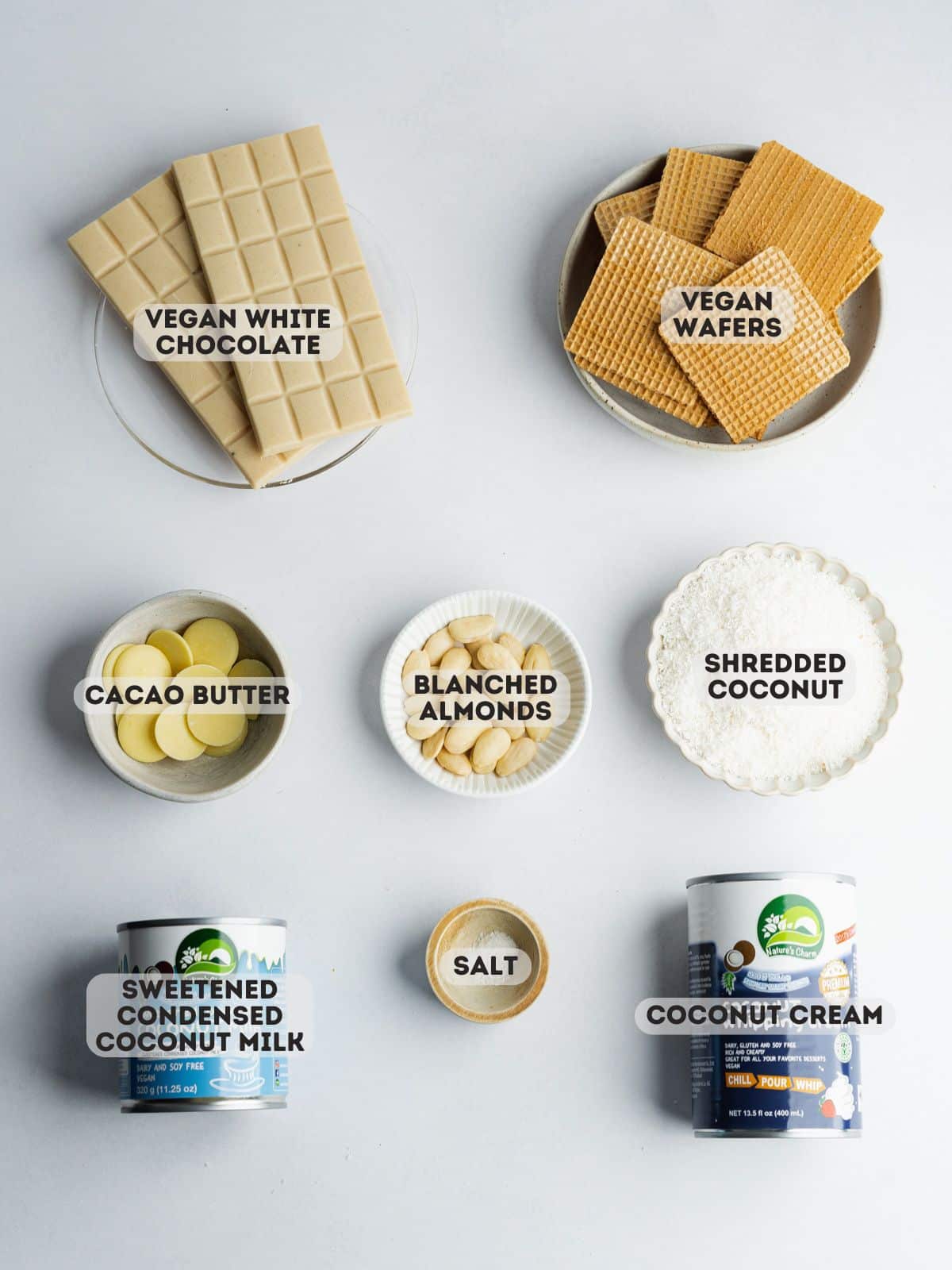 ingredients to make homemade coconut truffles measured out in bowls on a gray surface.