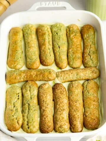 ladyfingers dipped in matcha and arranged in a baking dish.