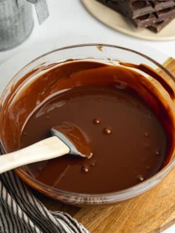 maple syrup, vanilla, and sea salt stirred into chocolate ganache in a clear bowl.