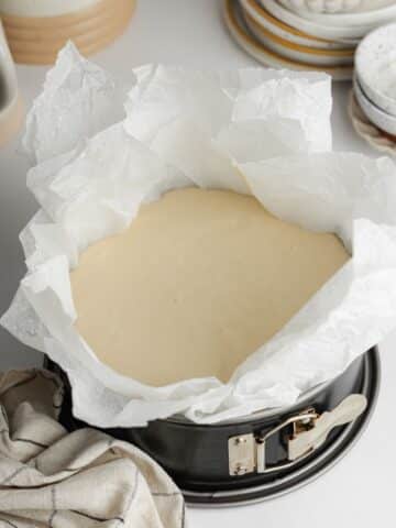 cheesecake batter in a lined pan before going into the oven.