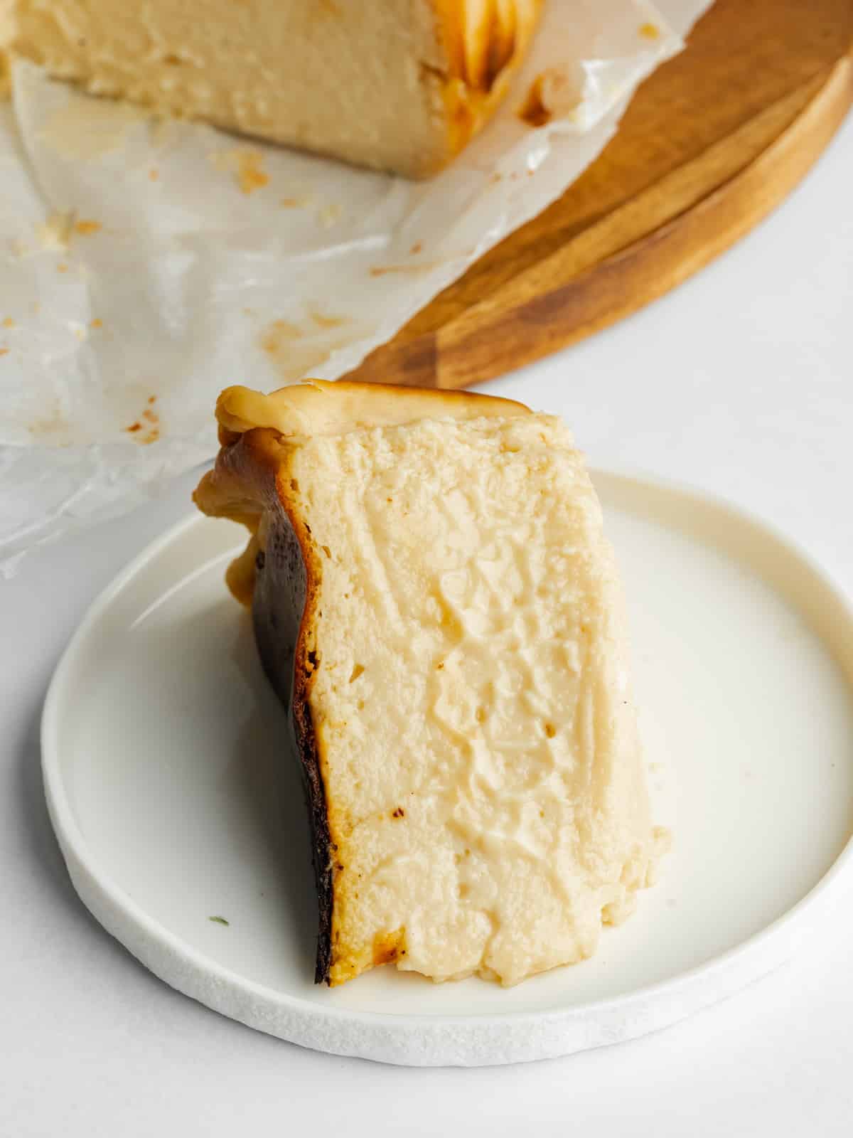 a slice of san sebastian cheesecake on a small white plate.