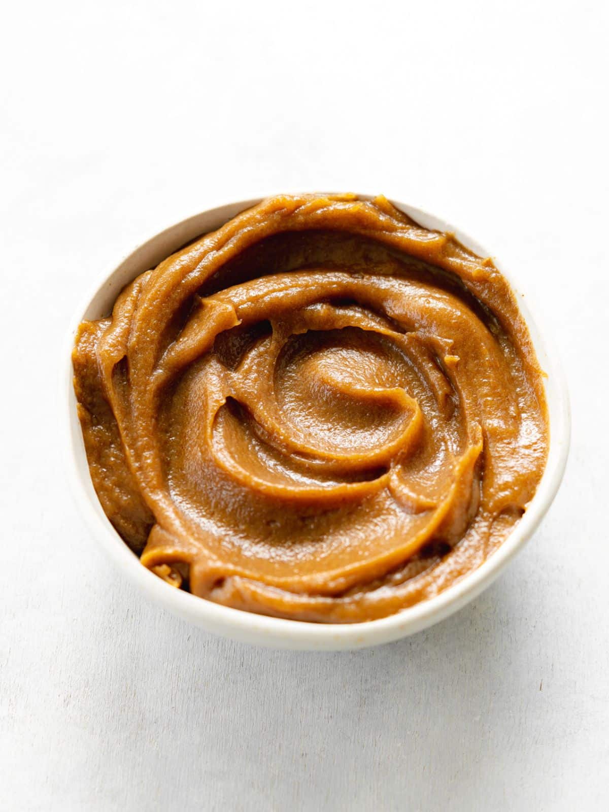 date caramel sauce swirled in a bowl.