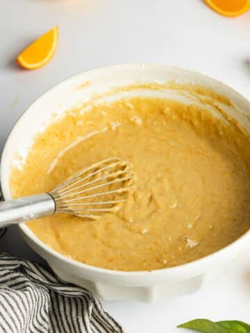 orange cake batter whisked in a large mixing bowl.