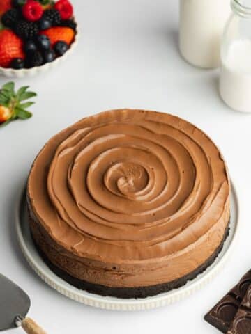 chocolate mousse cake with a swirl design on top of a white ceramic plate.
