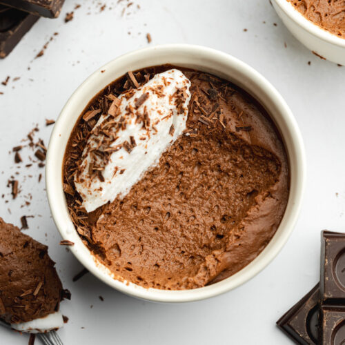 chocolate mousse with coconut cream on top and a spoonful taking showing the bubbly consistency.
