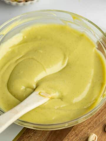 smooth pistachio custard cooling in a large mixing bowl.