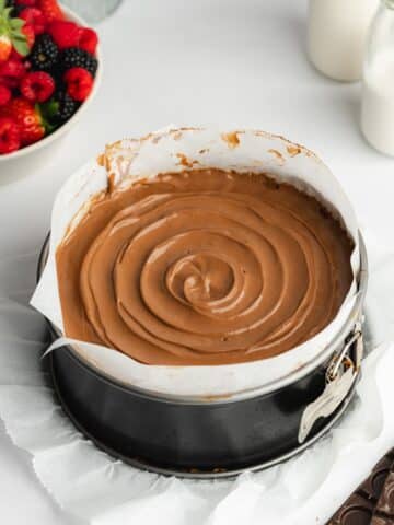 chocolate mousse cake in a pan lined with parchment before going into the fridge to set.