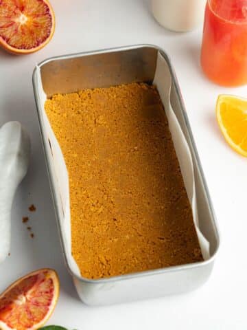 ginger cookie crust pressed evenly into the base of a lined loaf pan.