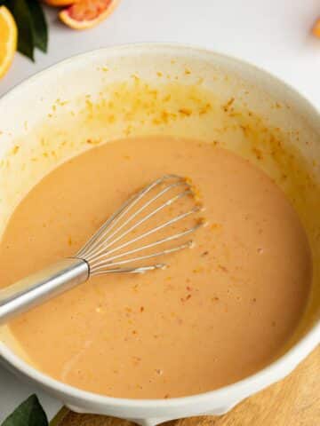 wet ingredients for orange cake whisked in a bowl.