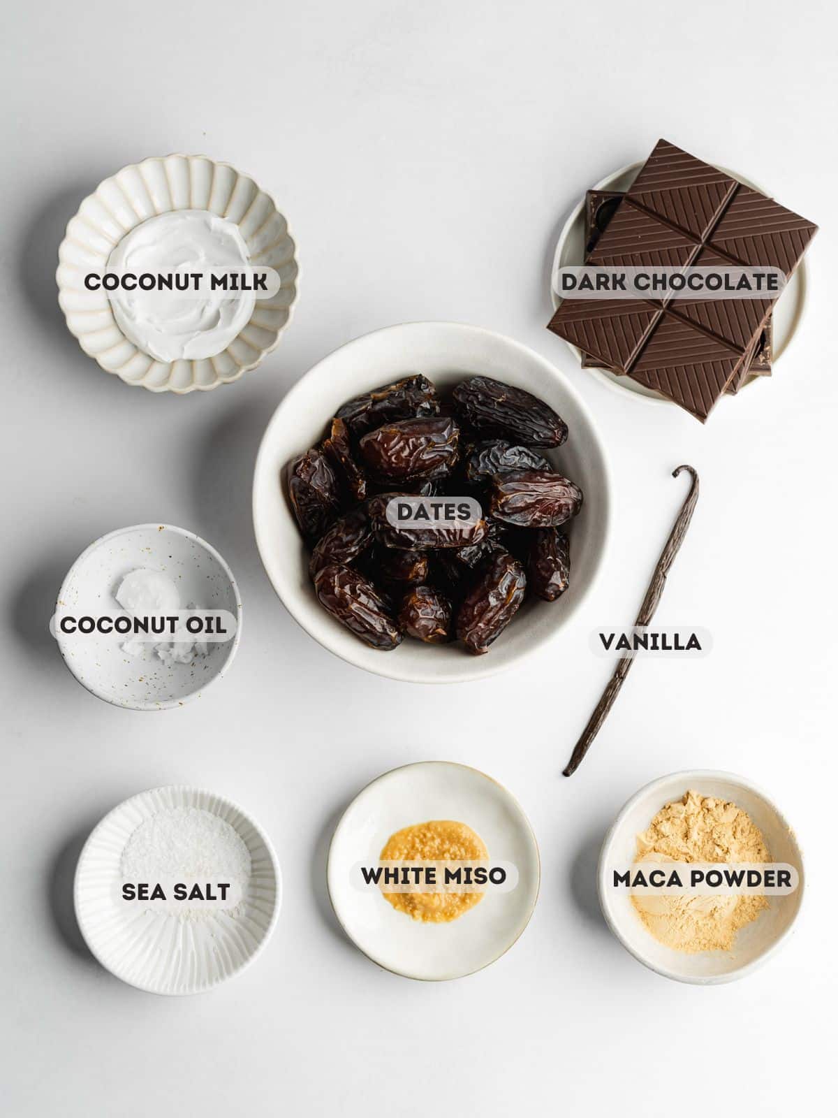ingredients to make date caramels measured out in bowls on a light gray surface.