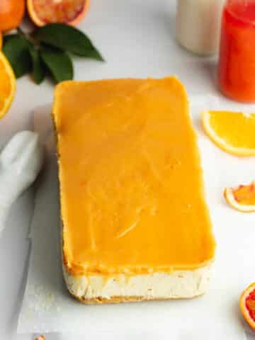 a slab of orange cheesecake with a layer of orange curd on top.