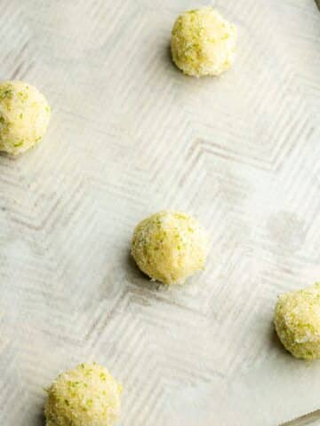 lime cookies spaced out on a cookie sheet lined with parchment paper.