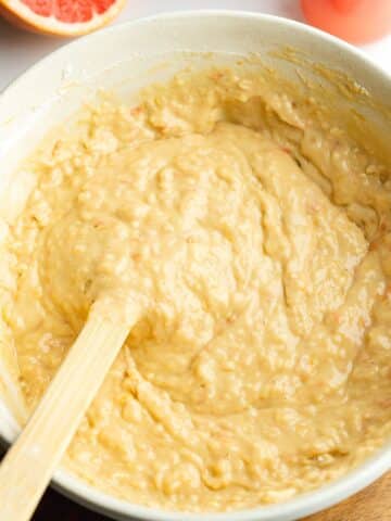 thick grapefruit cake batter in a mixing bowl with a rubber spatula.