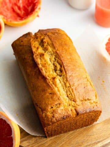 grapefruit loaf cake cooling on a sheet of parchment paper.