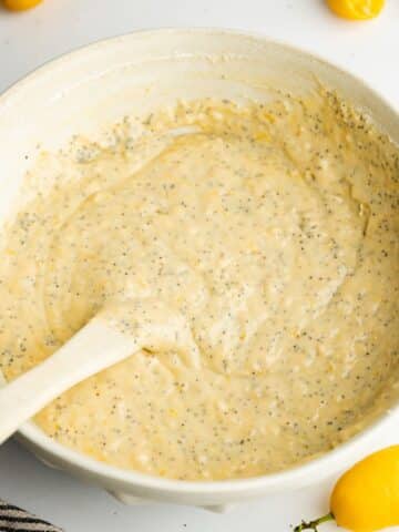 lemon poppy seed cake batter in a large mixing bowl with a rubber spatula.