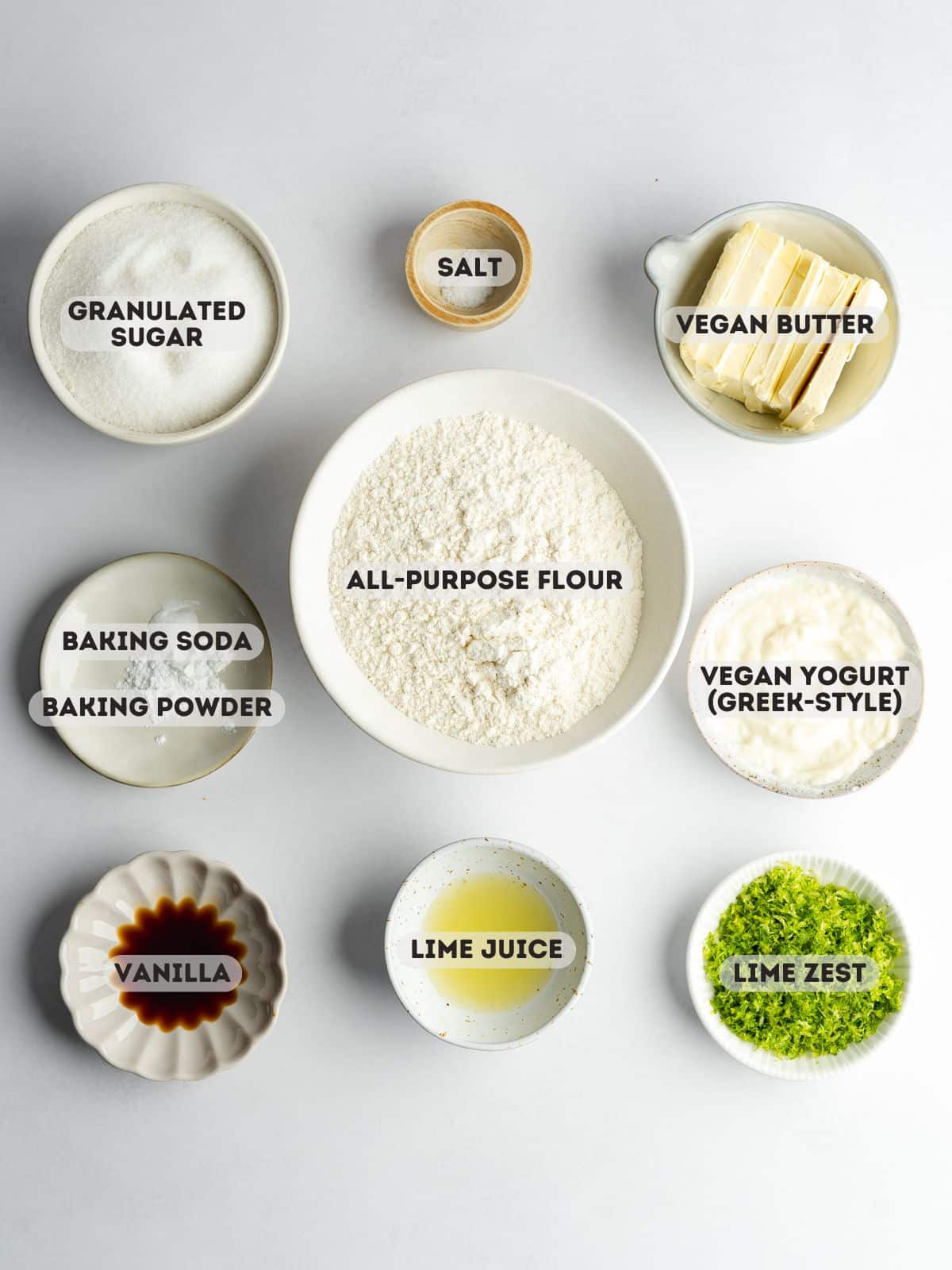 ingredients for homemade key lime cookies measured out in bowls with text overlay on a gray surface.