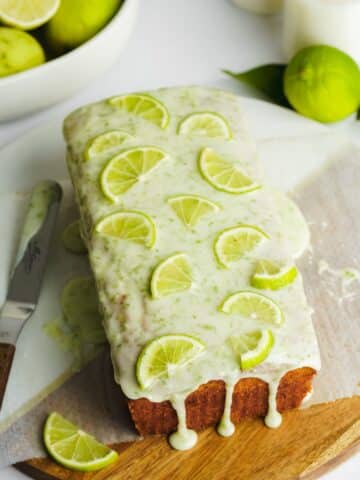 lime loaf cake with lime glaze and lime slices on top.