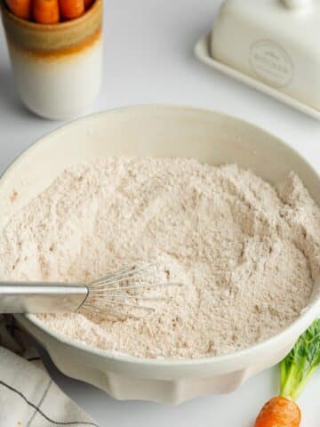 dry ingredients in a large ceramic bowl with a whisk.