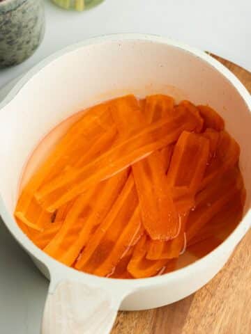 carrot slices cooking in sugar syrup.
