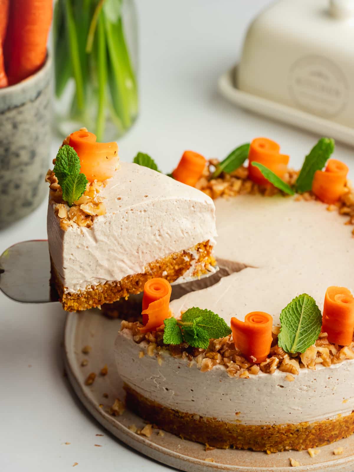 a slice of carrot cheesecake being lifted away on a cake slice.
